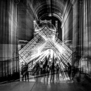 Vue nocturne de la pyramide du Louvre avec des silhouettes en mouvement et des jeux de lumière dynamiques.