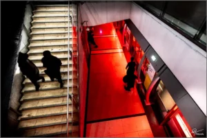 Escalier et couloir souterrain avec des ombres en mouvement et une lumière rouge intense